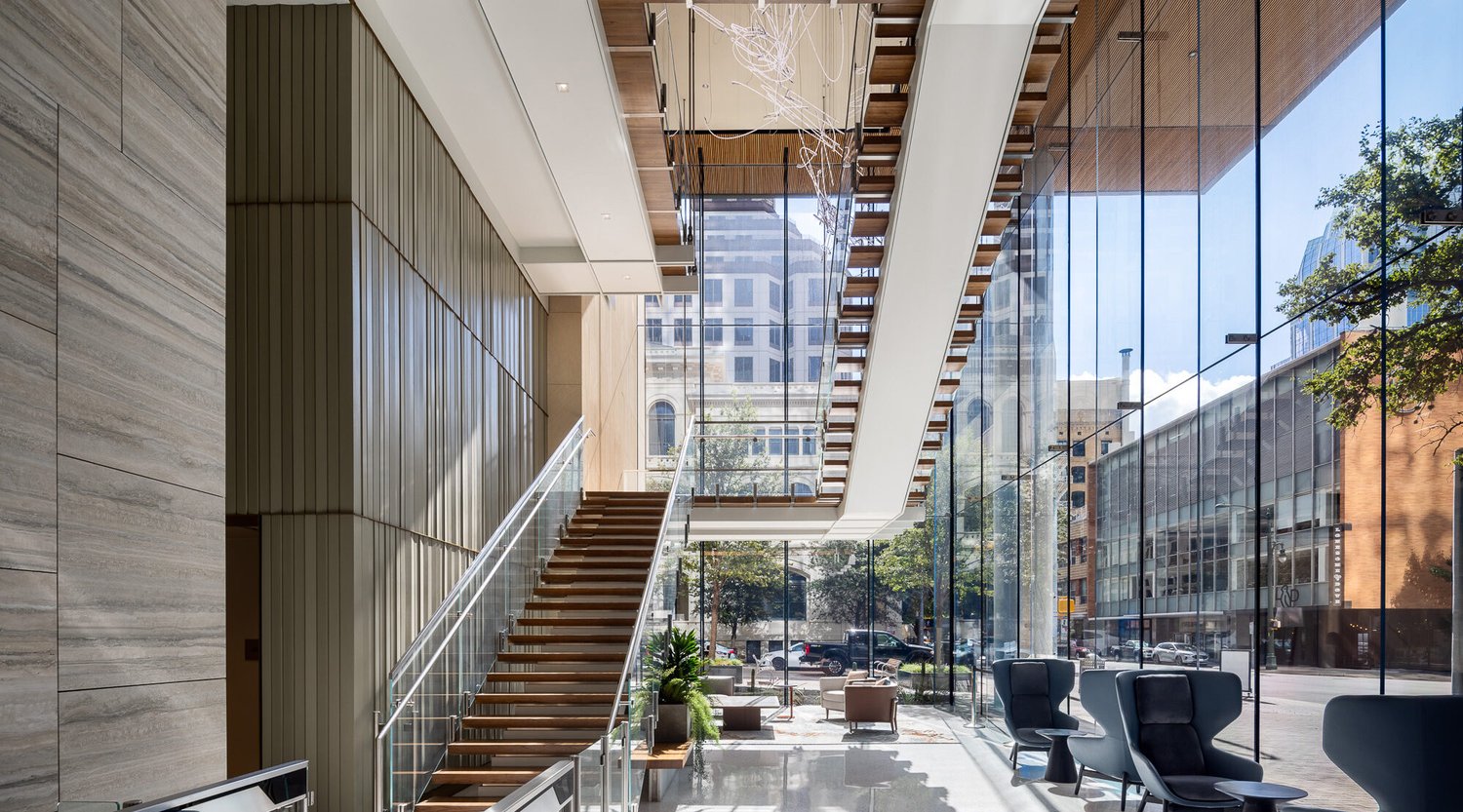 The lobby of Indeed Tower, featuring a sculptural stair and floor-to-ceiling glass