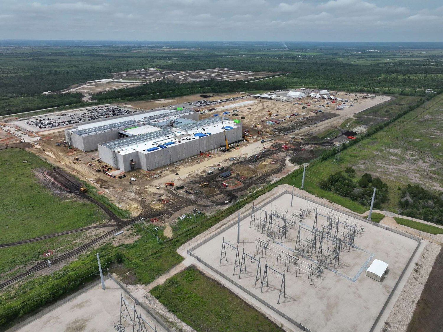 Aerial view of construction at the EdgeConneX Cedar Creek data center campus on FM 535, with on-site electrical substation in the foreground