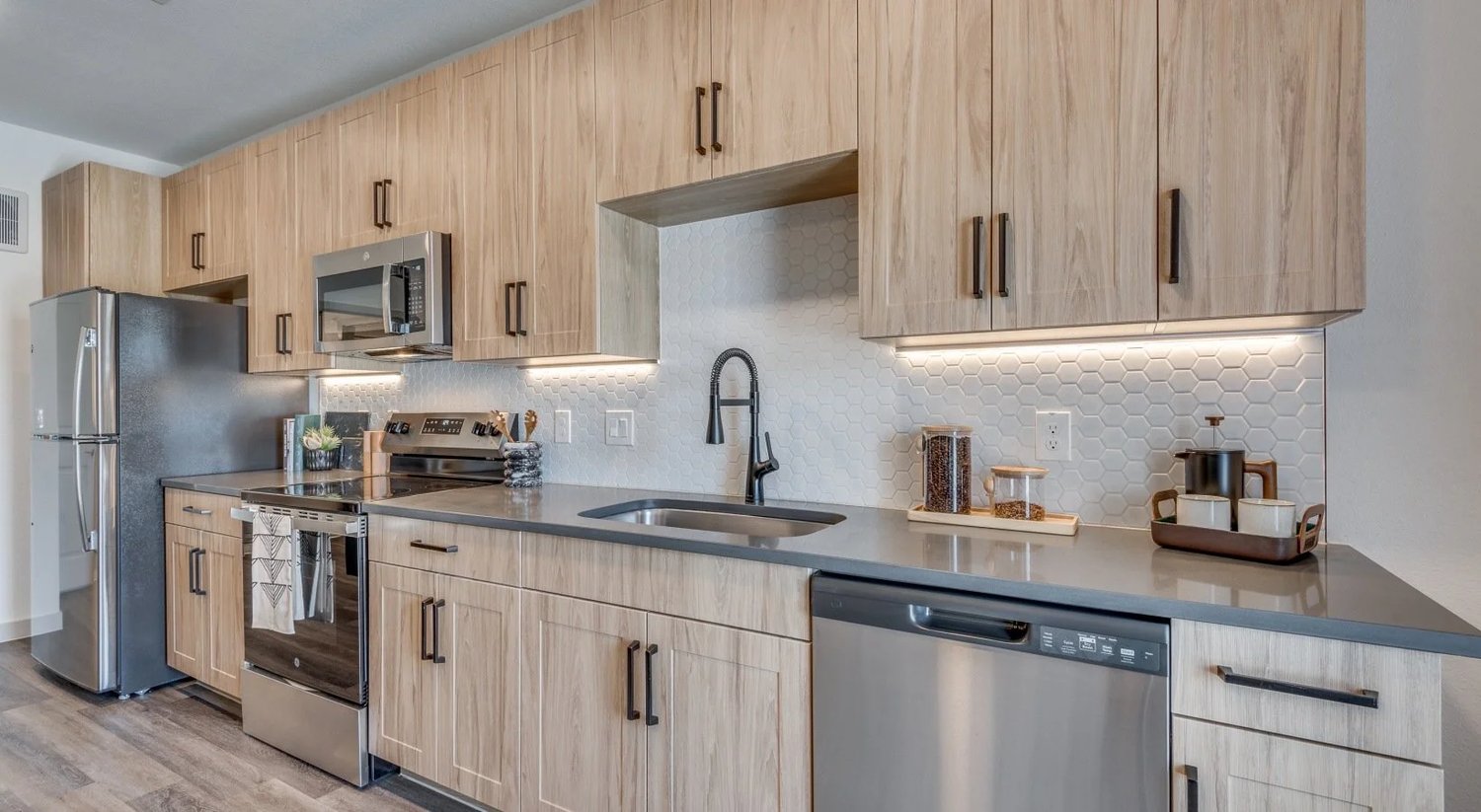 Kitchen with wood-tone cabinetry and stainless appliances at Strata